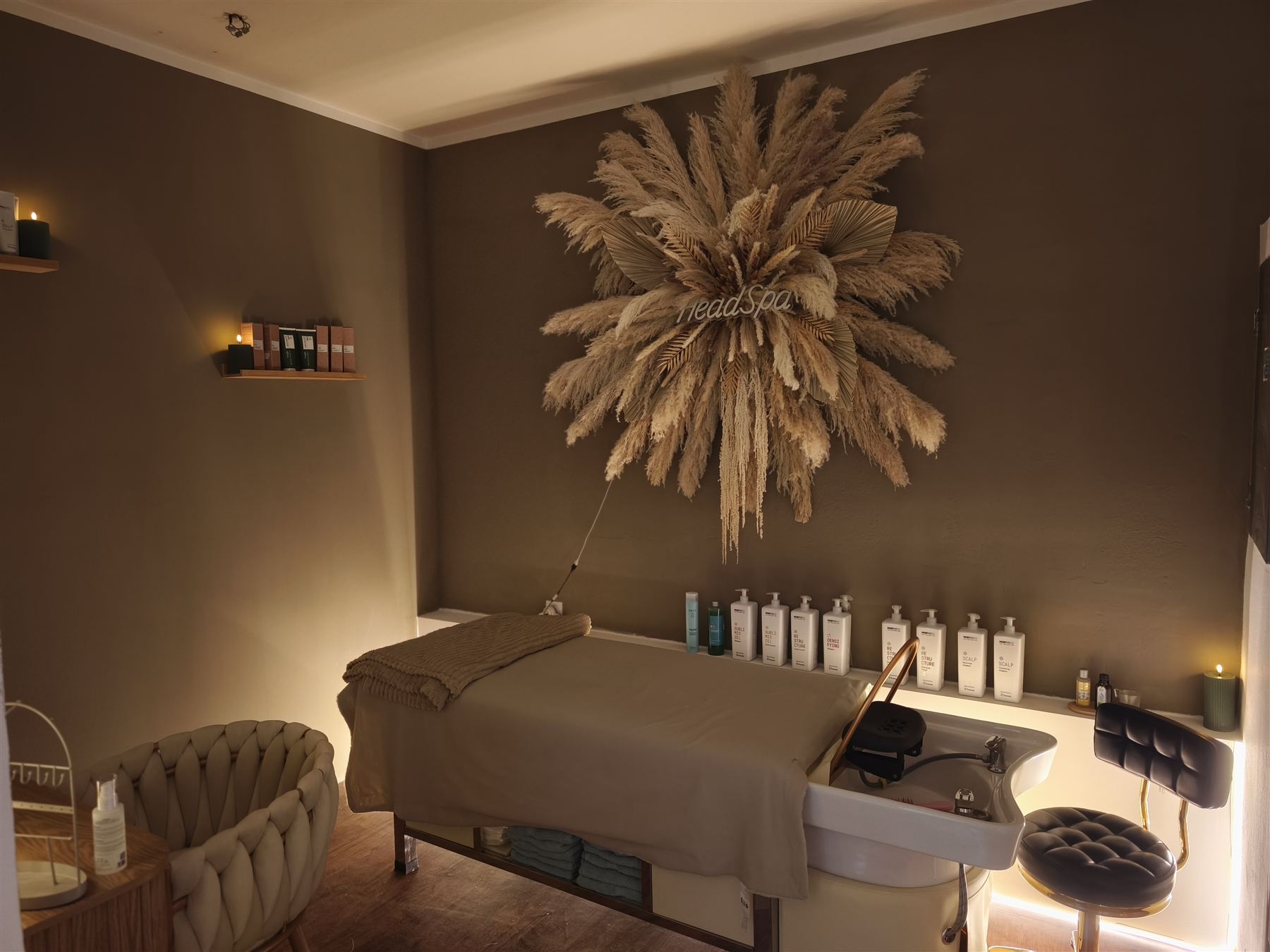 Místnost Head Spa s lehátkem a mycím umyvadlem ve večerním světle